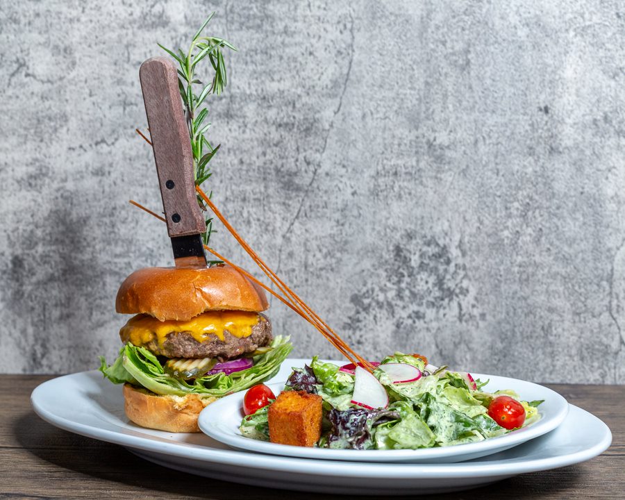 The Ultimate Guide to Dining at Hash House A Go Go Flamingo Crossings 1 Stuffed burger with bacon and cheddar served with fresh garden salad at Hash House A Go Go Flamingo Crossings dining location in Winter Garden, Florida