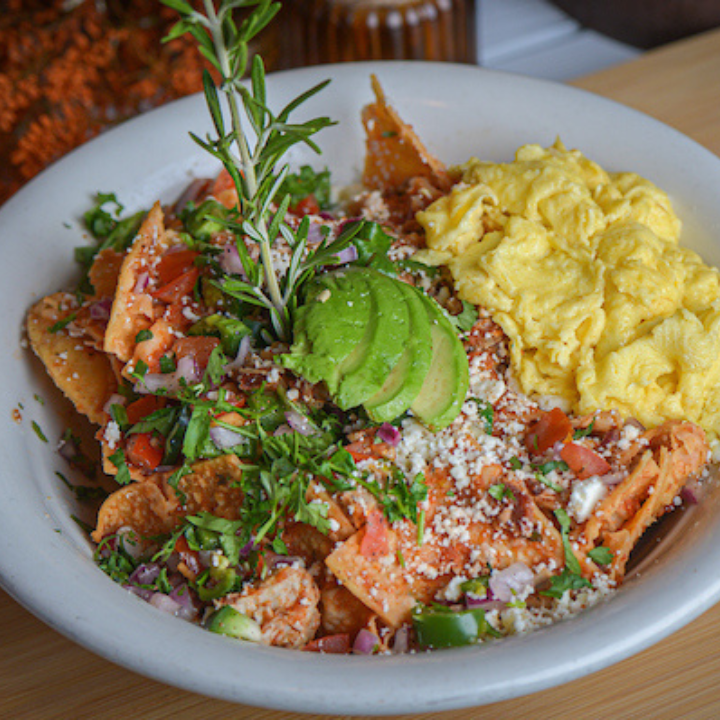 Exploring the Farm-to-Table Concept at Hash House A Go Go Flamingo Crossings 1 Farm to table chilaquiles breakfast bowl at Hash House A Go Go Flamingo Crossings, topped with avocado, scrambled eggs, and fresh herbs.
