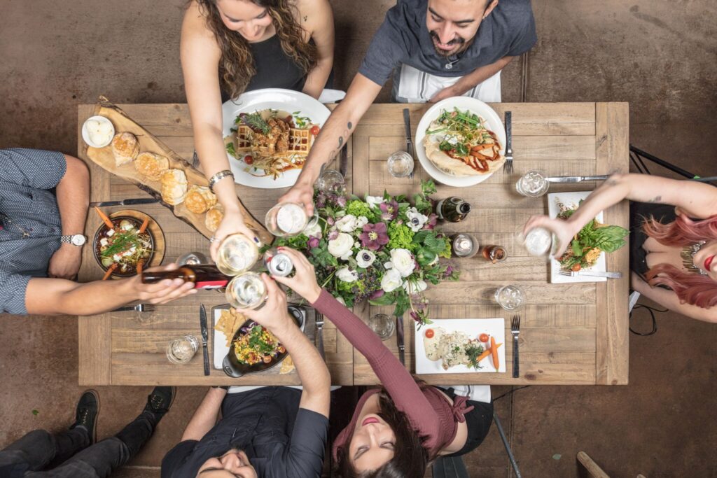 Group enjoying brunch at Hash House A Go Go Flamingo Crossings with signature twisted farm food dishes, craft drinks, and a lively dining atmosphere.