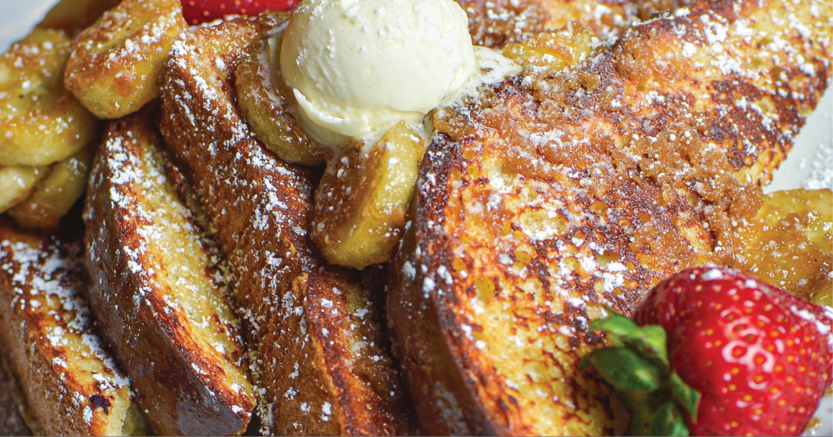 Banana-stuffed French toast topped with whipped cream and strawberries at Hash House Flamingo Crossings