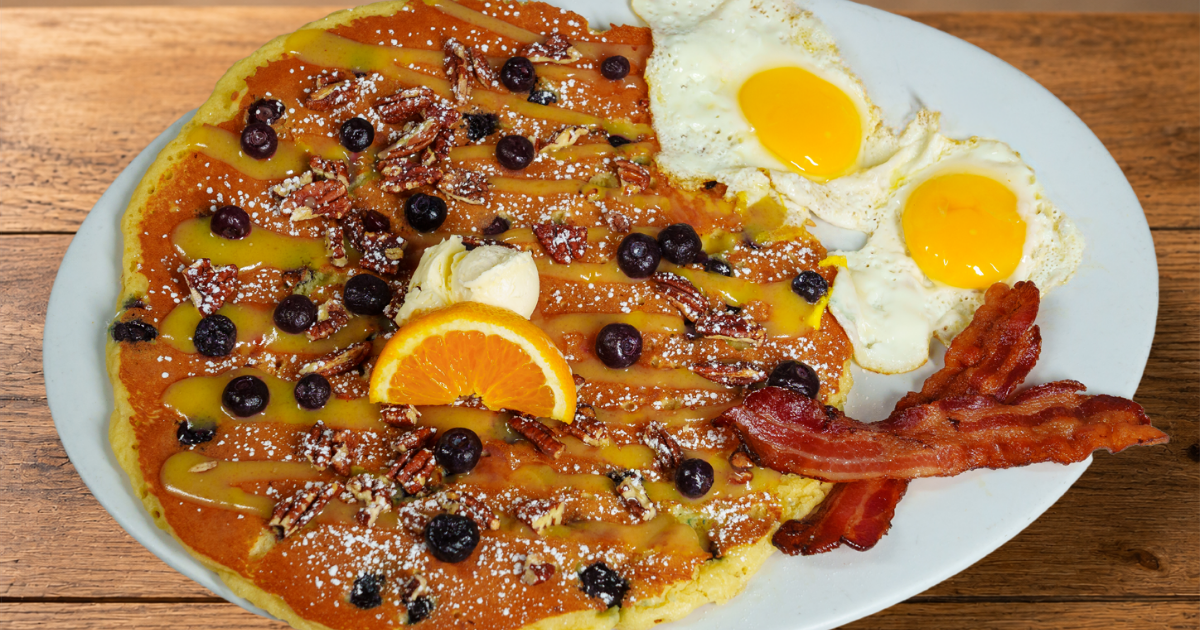 Blueberry Pecan & Lemon Glaze Flapjack with blueberries, candied pecans, eggs and bacon at Hash House A Go Go Flamingo Crossings